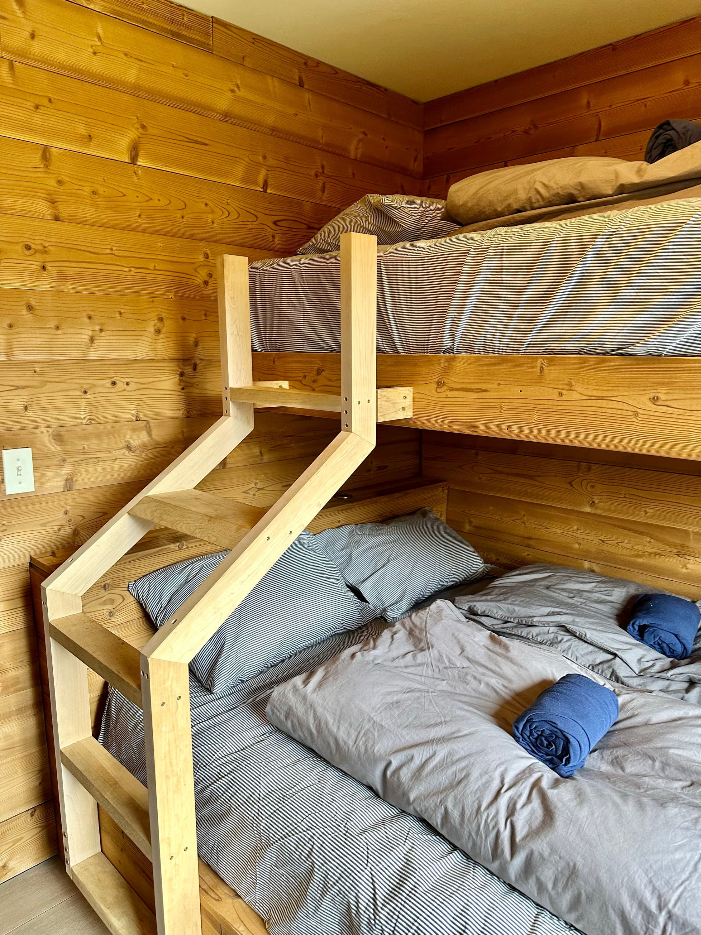 A made-up queen bunk in a private room
