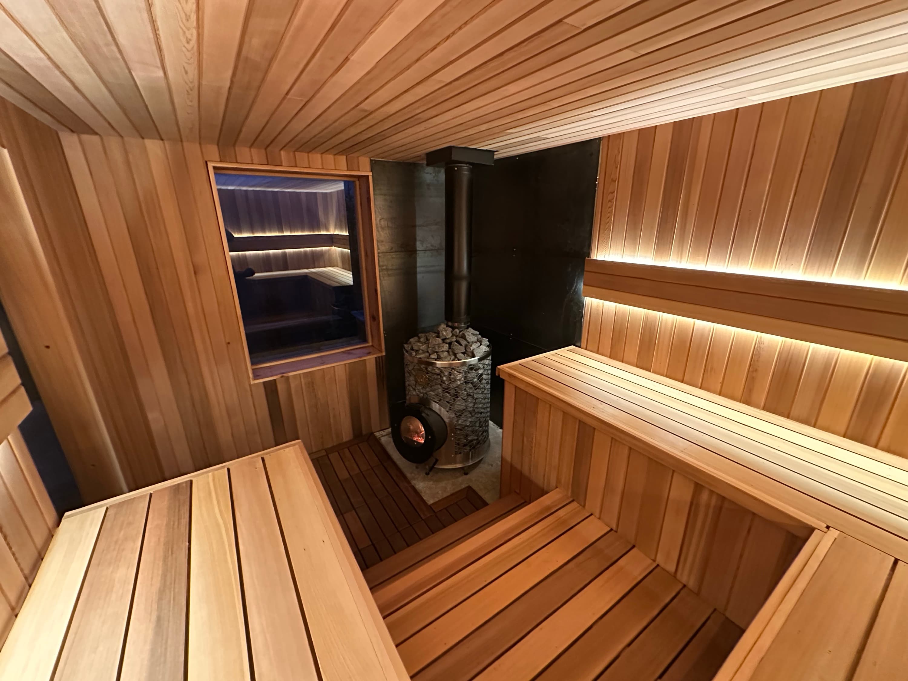 Cedar benches and stove in the wood-fired sauna
