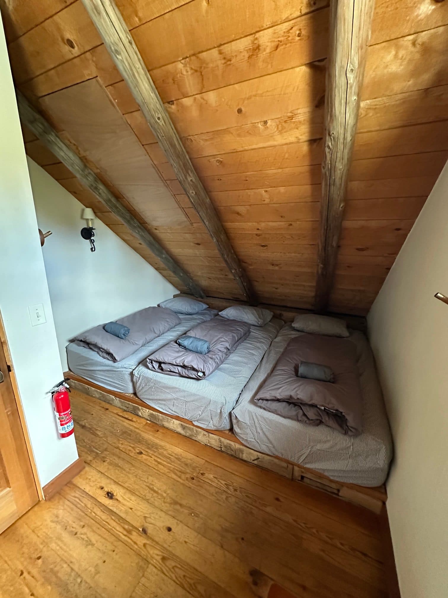 Three twin beds side by side in the West 5-person room